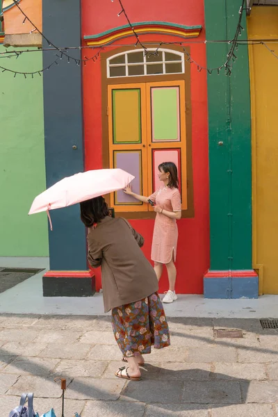 Singapur, Singapur - 1 Mayıs 2019 - Kimliği belirsiz iki kadın 1 Mayıs 2019'da Tan Teng Niah'ın eski evinin önünde fotoğraf çekiyor.
