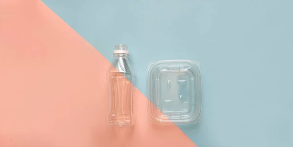Temiz plastik geri dönüşümlü su şişesi yemek kabı pastel arka plan. Basit minilal düz oda kopyalamak için soyut. Çapraz renkli kağıt pastel mavi ve pembe. Geri Dönüşüm, Yeniden Kullan