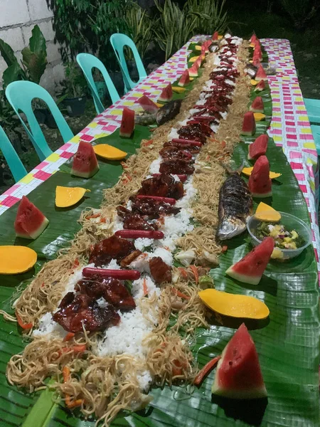 Geleneksel Filipinli aile yemeği olan Kamayan, muz yapraklarının üzerinde ellerinizle yediğiniz renkli bir yemektir. Pirinç ızgara et, mango, karpuz ve balık..