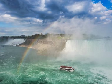 Mist Niagara Şelaleleri gökkuşağının altında geçen altında çevrili tekne.