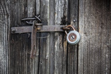 Eski paslı asma kilit bir ahşap kapı