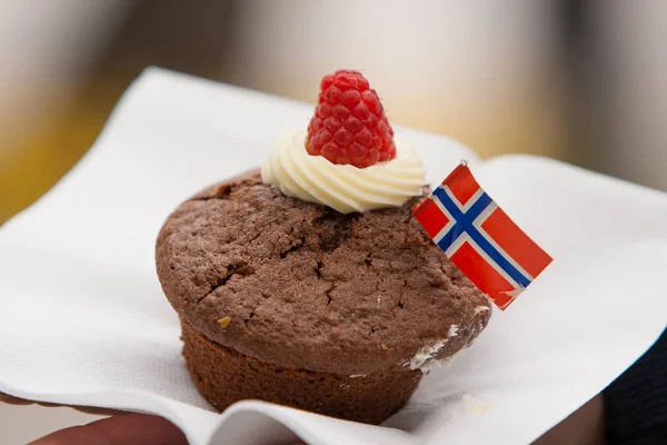 A chocolate cupcake  with Norwegian flag on a white napkin. Celebration ofr May 17th.