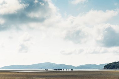 Yeşil dağ ile düşük gelgit peyzaj, Chon Buri, Sattahip District, Tayland Toong Pronge Bay arka planda insanlarla bulut gökyüzü.