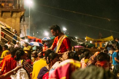 Hintli rahip gece yağmur yağarken, Varanasi Ganga Aarti kutsal Dasaswamedh Ghat, Kashi Vishwanath Tapınağı yakınında insanlar nimet, Varanasi, Hindistan.