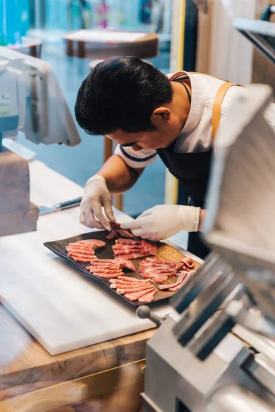 Asya kasap mutfakta taş plaka üzerinde yüksek mermer doku ile Wagyu A5 sığır eti birçok yerinde prim nadir dilimleri düzenliyor. Yakiniku (Izgara Et) için servis edilir).