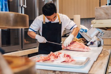 Asya kasap mutfakta taş plaka üzerinde yüksek mermer doku ile Wagyu A5 sığır eti birçok yerinde prim nadir dilimleri düzenliyor. Yakiniku (Izgara Et) için servis edilir).
