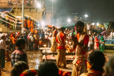 Hintli rahip gece yağmur yağarken, Varanasi Ganga Aarti kutsal Dasaswamedh Ghat, Kashi Vishwanath Tapınağı yakınında insanlar nimet, Varanasi, Hindistan.