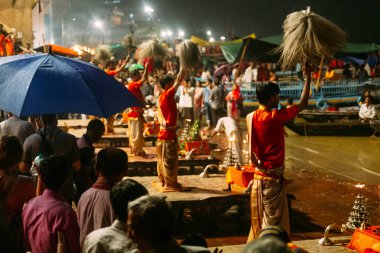 Hintli rahip gece yağmur yağarken, Varanasi Ganga Aarti kutsal Dasaswamedh Ghat, Kashi Vishwanath Tapınağı yakınında insanlar nimet, Varanasi, Hindistan.