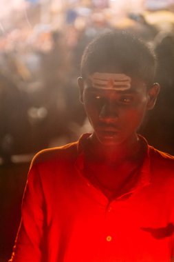 Genç Hintli çocuk kutsal Dasaswamedh Ghat de Varanasi Ganga Aarti alanında teknede kırmızı giyen, Kashi Vishwanath Tapınağı yakın, Varanasi, Hindistan.
