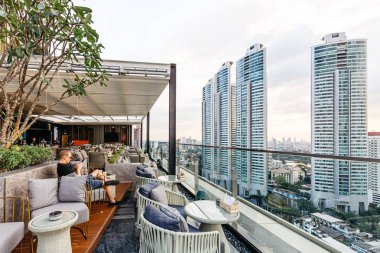 Beyaz hareketli çatı ve açık kanepe ile açık çatı bar. Bu alan Bangkok modern binaların bir görünüm alabilir.