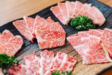 Close-up Premium Rare Slices many parts of Wagyu A5 beef with high-marbled texture on stone plate served for Yakiniku (Grilled Meat). clipart