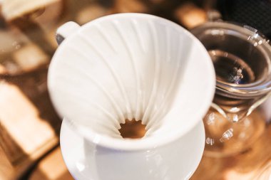 Yakın çekim seramik Pour Over damlama denilen alternatif yöntem ile dökme kahve yapmak için. Kahve öğütücü, kahve standı ve dökme-üzerine ahşap bir masa üzerinde.