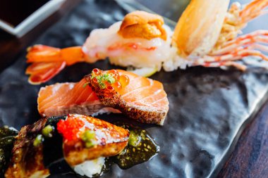 En iyi sushi seti 'nde, wasabi ve pembe turşulu zencefil ile servis edilen Deep Fried Shrimp with Sea Urchin, Foie Gras, Somon and Engawa bulunmaktadır. Somon Suşi 'ye yakın çekim.