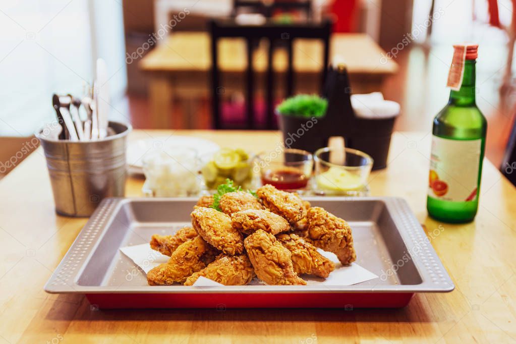 Golden Crunchy Korean Fried Chicken (basic Huraideu-Chikin) served with pickled and Soju. In South Korea, fried chicken is consumed as a meal, an appetizer, Anju, or as an after-meal snack.