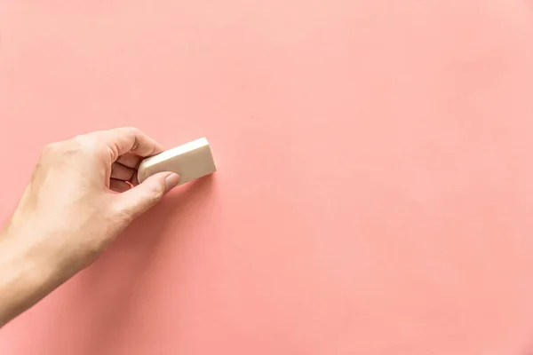 Mano Sosteniendo Goma Blanca Para Borrar Algo Sobre Fondo Rosa — Foto de Stock