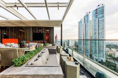 Beyaz hareketli çatı ve açık kanepe ile açık çatı bar. Bu alan Bangkok modern binaların bir görünüm alabilir.