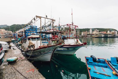 Yehliu fishing harbor with fisherman boats floating on the river in fisherman village in northern Taipei. clipart