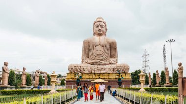 Daibutsu, Büyük Buda Heykeli meditasyon pozunda ya da Dhyana Mudra Hindistan 'ın Bodh Gaya kentindeki Mahabodhi Tapınağı yakınlarındaki ağaçlarla birlikte açık havada bir nilüfer üzerinde oturuyordu..
