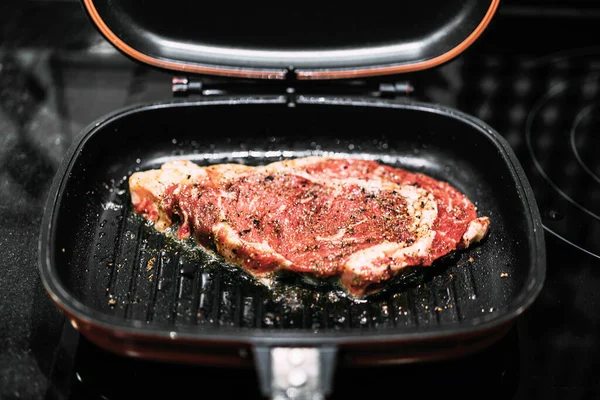 Şef kurutulmuş sığır eti, trüf yağı, sarımsak ve karabiber ile sığır filetosu pişiriyor. Ev mutfağından yemek işi. Keto diyet yaşam tarzı.