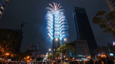 TAPEI, TAIWAN. JAN 1, 2018: Taipei Şehir Gecesi manzarası ve Taipei 101 gökdeleni havai fişeklerle aydınlatıldı. İnsanlar yeni yılı kutlamak için binaların etrafında fotoğraf ve video çekiyorlar..