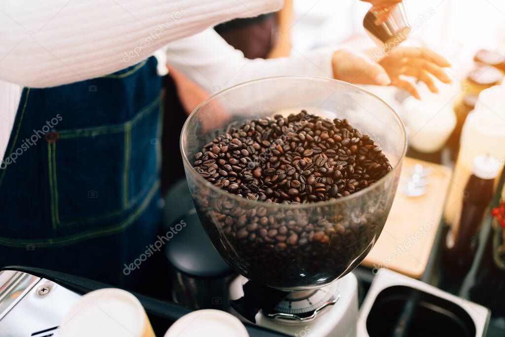 Close-up coffee beans inside Electric Coffee Grinder Grinding Machine. Coffee Mill Both Household And Business Machine. Coffee-making class for start-up entrepreneurs to starts a small business.