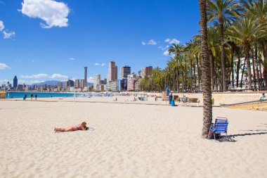 Alicante İspanya Benidorm güzel plaj, yerel Playa de Levante plaj olarak bilinen plaj, plaj ve aynı zamanda güzel bir mavi gökyüzü gününde yüksek katlı otel ve ofisler gösteren.