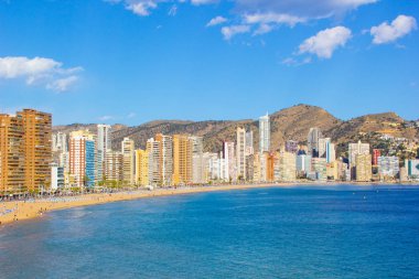 Alicante İspanya Benidorm güzel plaj, yerel Playa de Levante plaj olarak bilinen plaj, plaj ve aynı zamanda güzel bir mavi gökyüzü gününde yüksek katlı otel ve ofisler gösteren.