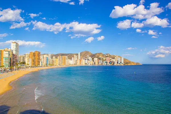Alicante İspanya Benidorm güzel plaj, yerel Playa de Levante plaj olarak bilinen plaj, plaj ve aynı zamanda güzel bir mavi gökyüzü gününde yüksek katlı otel ve ofisler gösteren.