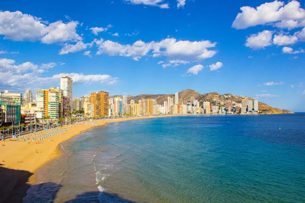Alicante İspanya Benidorm güzel plaj, yerel Playa de Levante plaj olarak bilinen plaj, plaj ve aynı zamanda güzel bir mavi gökyüzü gününde yüksek katlı otel ve ofisler gösteren.