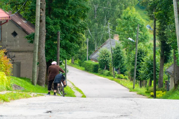 Вид Сзади Старуху Толкающую Велосипед Вдоль Дороги Маленького Городка Летом — стоковое фото