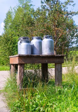 Garaj yolundaki süt masası ve alüminyum camlar. Letonya'da yaz aylarında Latgale
