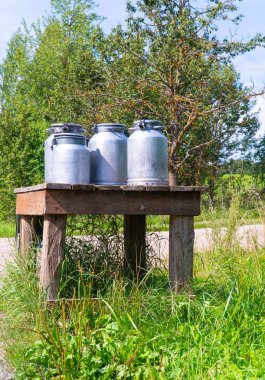 Garaj yolundaki süt masası ve alüminyum camlar. Letonya'da yaz aylarında Latgale