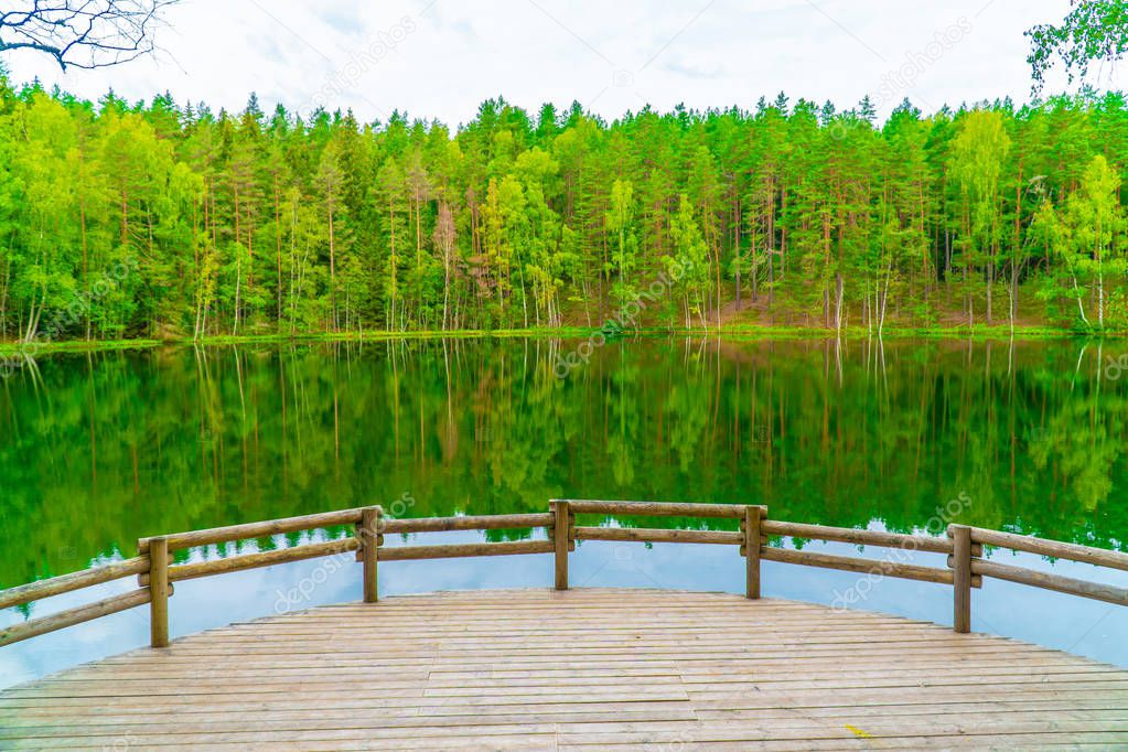 The Devil's Lake, mysterious lake in middle of forest, forest and trees are reflected in the lake water, Aglona, Latvia