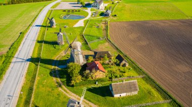 Uçan İHA 'dan yaz tarlalarına ve Leisi Parish' teki Angla yel değirmenlerine güzel panoramik hava manzaralı fotoğraf. Saarema Adası, Estonya. (seri)