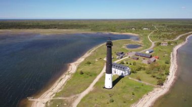 Güneşli Sorve deniz fenerinde uçan İHA 'dan güzel panoramik 4K video. Saaremaa Adası Estonya 'daki silindirik beton deniz feneri (Seriler))