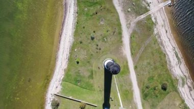 Güneşli Sorve deniz fenerinde uçan İHA 'dan güzel panoramik 4K video. Saaremaa Adası Estonya 'daki silindirik beton deniz feneri (Seriler))