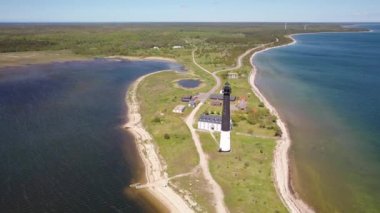 Güneşli Sorve deniz fenerinde uçan İHA 'dan güzel panoramik 4K video. Saaremaa Adası Estonya 'daki silindirik beton deniz feneri (Seriler))