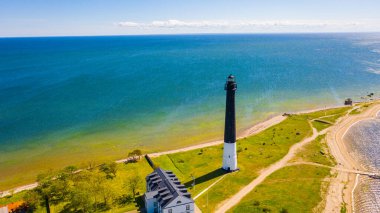 Güneşli Sorve deniz fenerinin üzerinde uçan dron 'dan güzel panoramik hava manzaralı fotoğraf. Saaremaa Adası Estonya 'daki silindirik beton deniz feneri (Seriler)) 