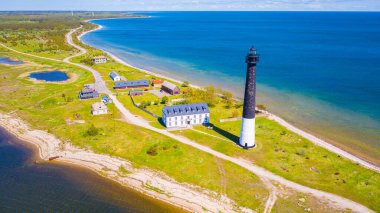 Beautiful panoramic aerial view photo from flying drone over sunny Sorve lighthouse. The cylindrical concrete lighthouse in Saaremaa island Estonia (Series)  clipart