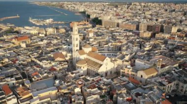 Gün batımında insansız hava aracıyla Bari 'nin eski bir kasabası olan Cathedral Saint Sabino' ya, San Nicola Bazilikası 'na ve yaz akşamları tarihi Bari kasabasına uçmaktan güzel panoramik 4K video. Bari, Apulia, İtalya (Seriler)