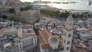Gün batımında insansız hava aracıyla Bari 'nin eski bir kasabası olan Cathedral Saint Sabino' ya, San Nicola Bazilikası 'na ve yaz akşamları tarihi Bari kasabasına uçmaktan güzel panoramik 4K video. Bari, Apulia, İtalya (Seriler)