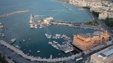 Gün batımında insansız hava aracıyla Bari Apulia City liman botları ve yatları, Teatro Margherita ve Bari şehrinin ufuk çizgisine güzel bir 4K panoramik video. Bari, Apulia, İtalya (Seriler)