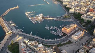 Gün batımında insansız hava aracıyla Bari Apulia City liman botları ve yatları, Teatro Margherita ve Bari şehrinin ufuk çizgisine güzel bir 4K panoramik video. Bari, Apulia, İtalya (Seriler)