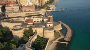 Deniz kanalındaki Eski Ortaçağ Aragonese Kalesi 'nde uçan İHA' dan güzel panoramik hava 4K videosu, günbatımında eski Taranto şehri, Puglia (Apulia), İtalya (Seriler))