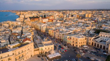 Eski Katedral San Corrado (Duomo Vecchio) ile Molfetta rıhtımında uçan İHA 'dan güzel panoramik hava manzaralı fotoğraf, gemi ve yatlarla liman ve Molfetta şehir günbatımı. Apulia, İtalya