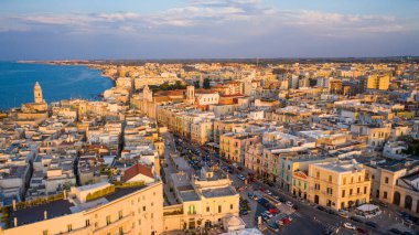 Eski Katedral San Corrado (Duomo Vecchio) ile Molfetta rıhtımında uçan İHA 'dan güzel panoramik hava manzaralı fotoğraf, gemi ve yatlarla liman ve Molfetta şehir günbatımı. Apulia, İtalya