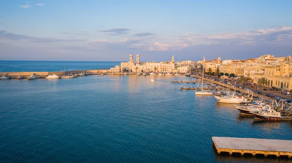 Eski Katedral San Corrado (Duomo Vecchio) ile Molfetta rıhtımında uçan İHA 'dan güzel panoramik hava manzaralı fotoğraf, gemi ve yatlarla liman ve Molfetta şehir günbatımı. Apulia, İtalya