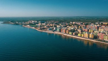 Molfetta rıhtımından ve eski kasabadan gelen güzel panoramik hava manzaralı fotoğraf. Gemileri ve yatları olan liman, Molfetta 'nın güneş doğarken yeni şehrini kapsıyor.)