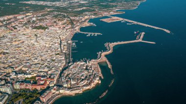 Molfetta rıhtımından ve eski kasabadan gelen güzel panoramik hava manzaralı fotoğraf. Gemileri ve yatları olan liman, Molfetta 'nın güneş doğarken yeni şehrini kapsıyor.)
