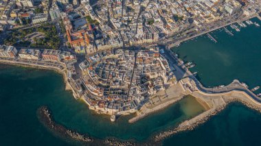 Molfetta rıhtımından ve eski kasabadan gelen güzel panoramik hava manzaralı fotoğraf. Gemileri ve yatları olan liman, Molfetta 'nın güneş doğarken yeni şehrini kapsıyor.)